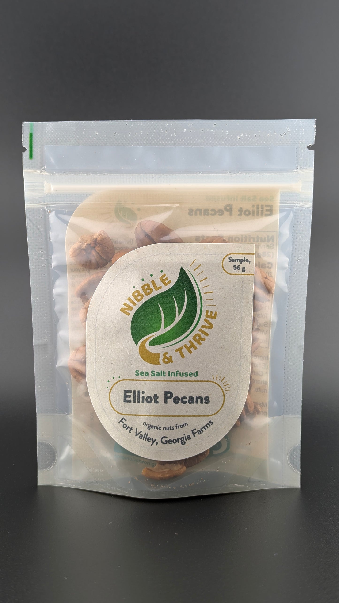 A resealable bag contains organic light sea salt-infused Elliot Pecans. The label reads Nibble & Thrive with a note stating Sample 54g and highlights these nutritious snacks as from Fort Valley, Georgia Farms.